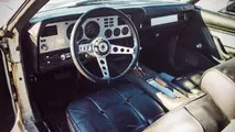 Side profile of a 1977 Ford Mustang Cobra II featuring window louvers and prominent graphics