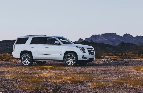 Side profile of a Cadillac Escalade luxury SUV, showcasing its commanding presence and distinctive American design.