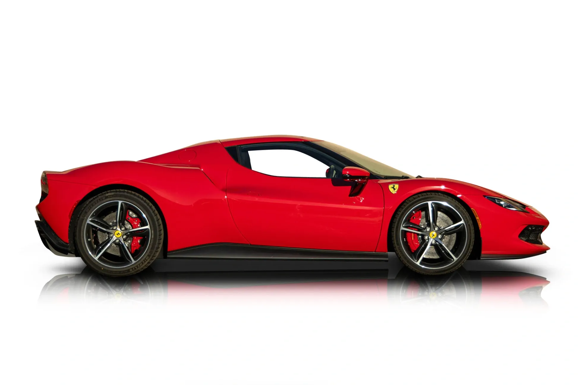 Side view of a red 2024 Ferrari 296 GTB parked on a city street