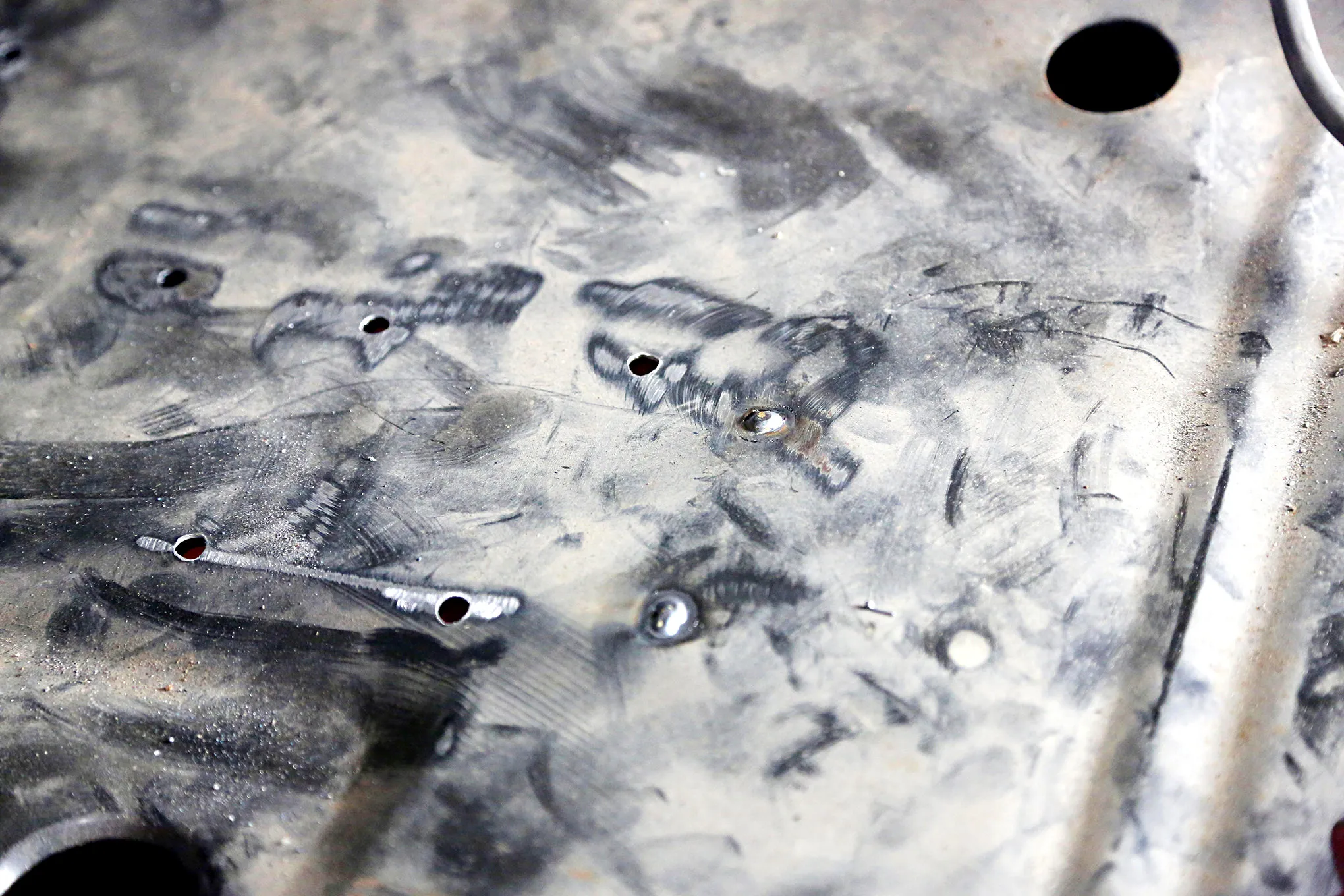 Spot welding the new floor pan into position in the 1969 Mustang Coupe chassis