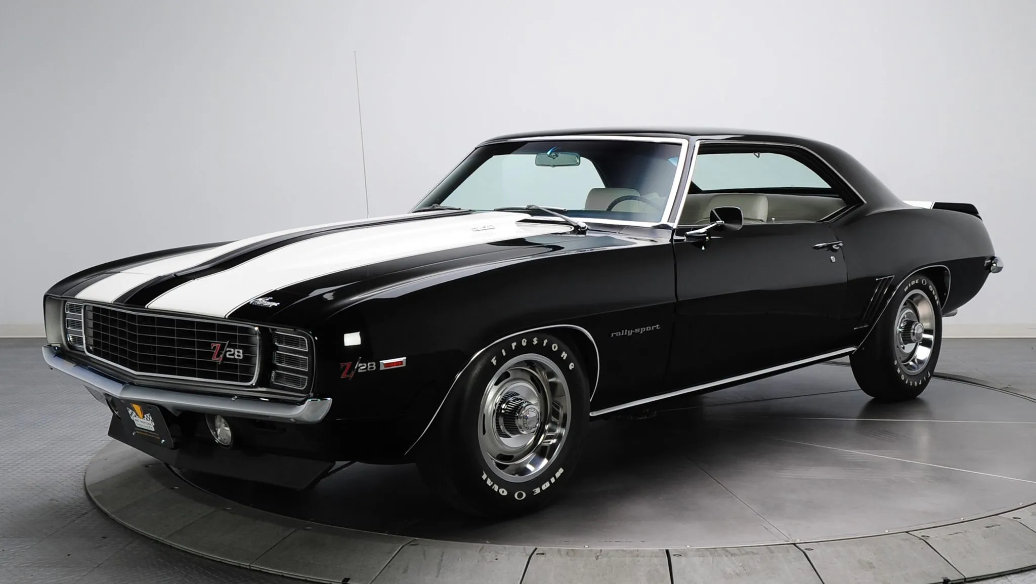 Striking front view of a white 1969 Chevy Camaro Z/28 with bold racing stripes, an iconic first-generation model.