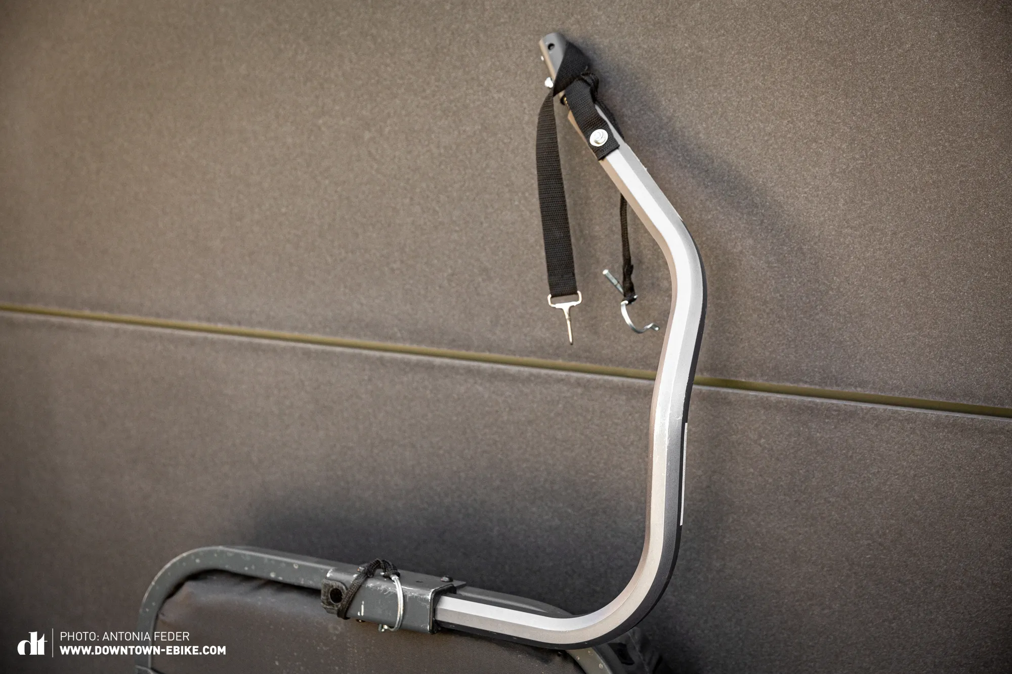 The drawbar of a dog bike trailer is shown dragging on the ground, indicating it is too short for safe cornering.
