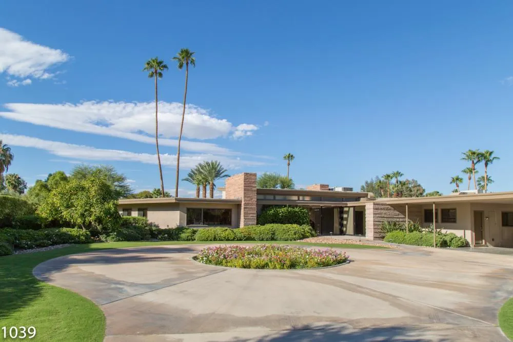 The iconic exterior of Frank Sinatra's Twin Palms estate in Palm Springs, showcasing its classic mid-century modern design and lush landscaping.