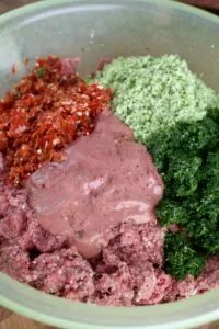 The processed vegetable and liver mixture being added to the meat mixture
