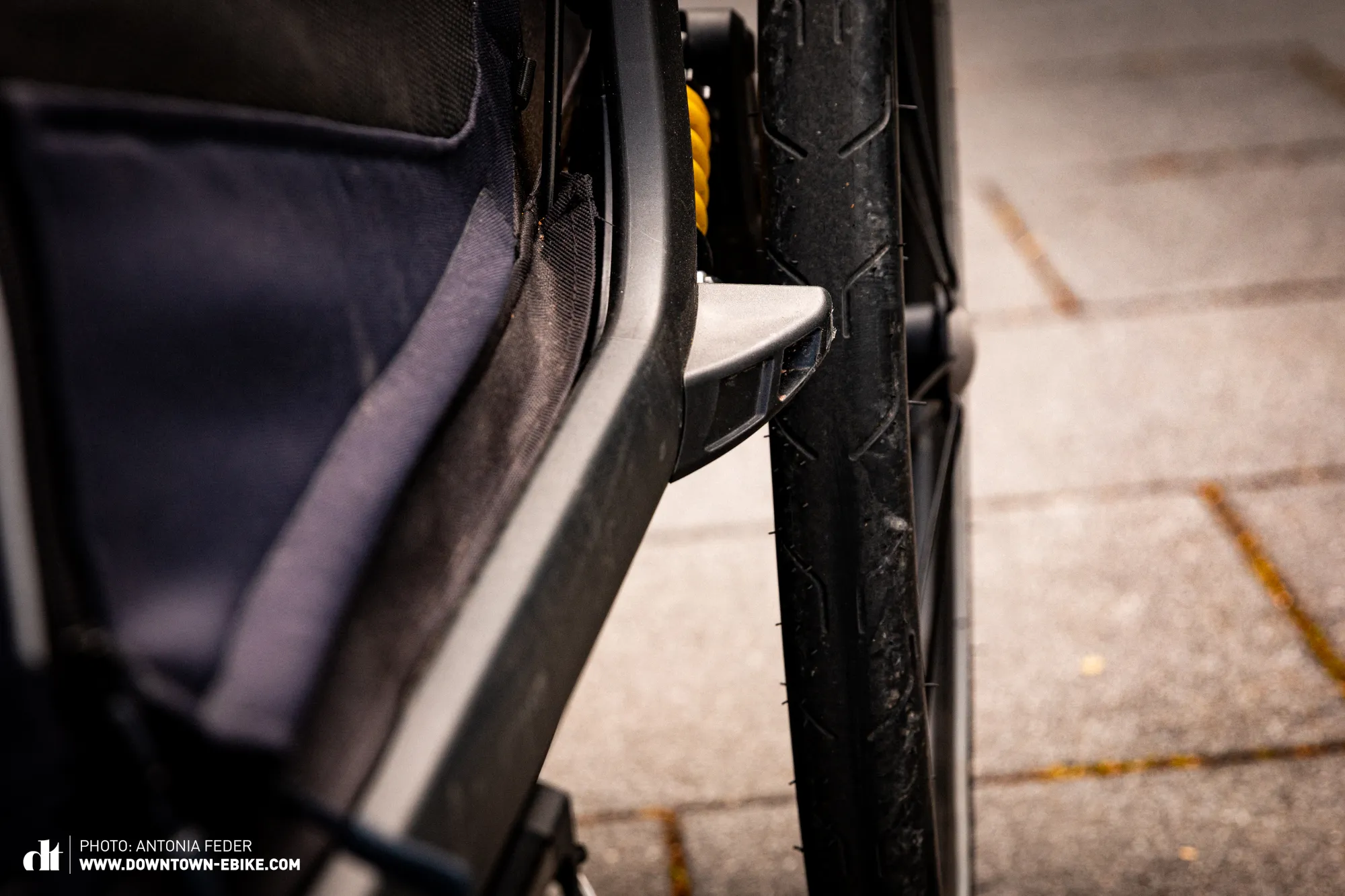 The small deflectors on a dog trailer are shown not adequately protecting the bicycle wheels.