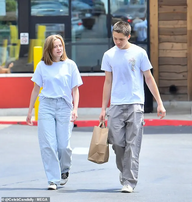 Vivienne in a white tee and pinstriped trousers