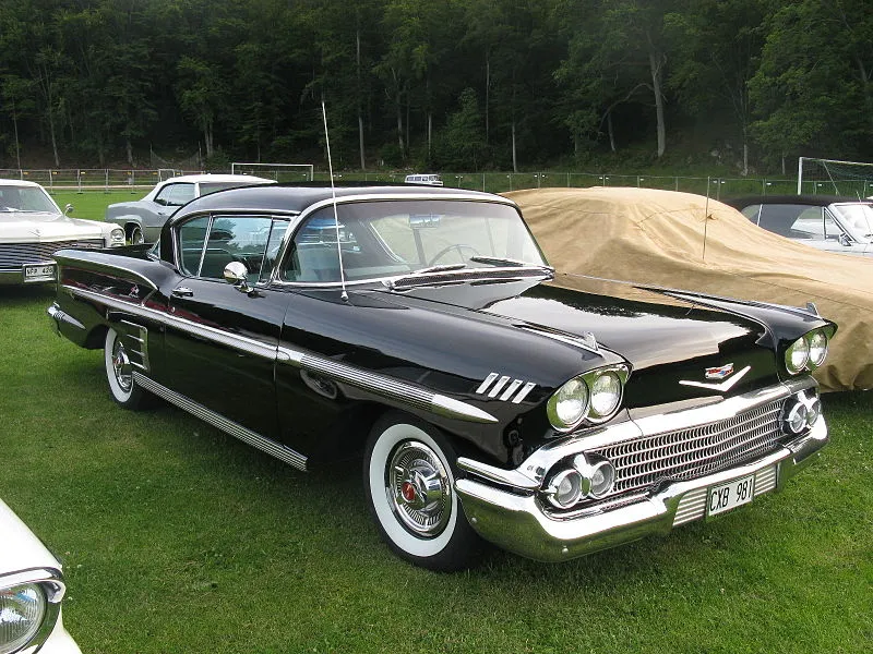 1958 Chevrolet Impala in a classic deep red, showcasing its iconic rear design