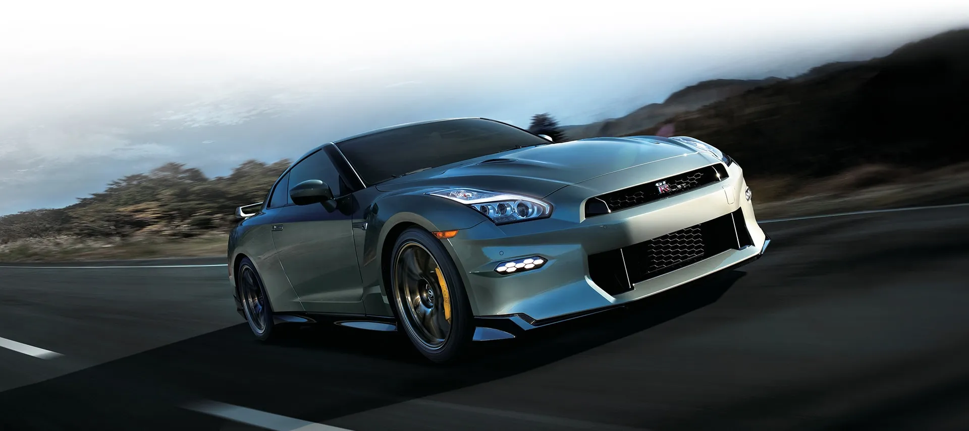 2024 Nissan GT-R NISMO front view while driving around a canted racetrack.