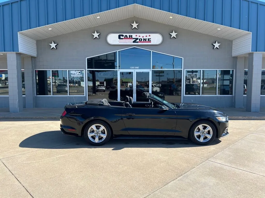 A black 2017 Ford Mustang V6 Convertible in a dealership lot.