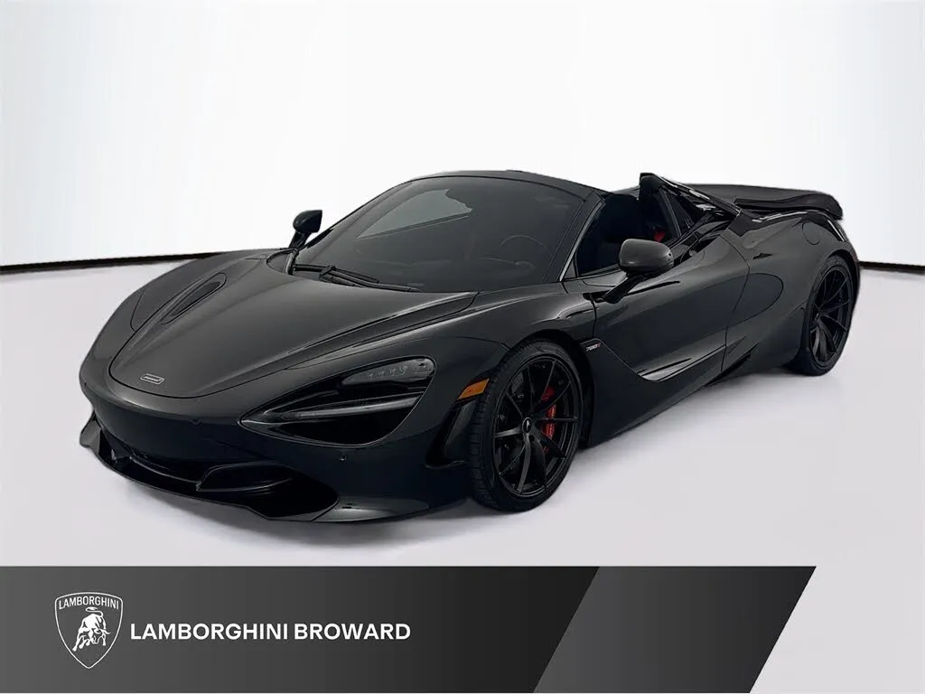 A black 2022 McLaren 720S Coupe, highlighting its sleek aerodynamic profile against a modern architectural background.