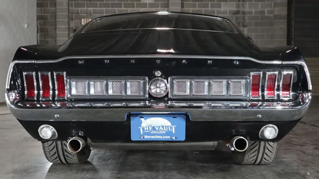 A classic muscle car prominently displayed in a car dealership showroom