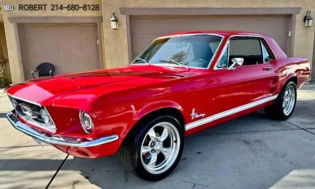 A classic red 1967 Ford Mustang coupe with black interior parked outdoors