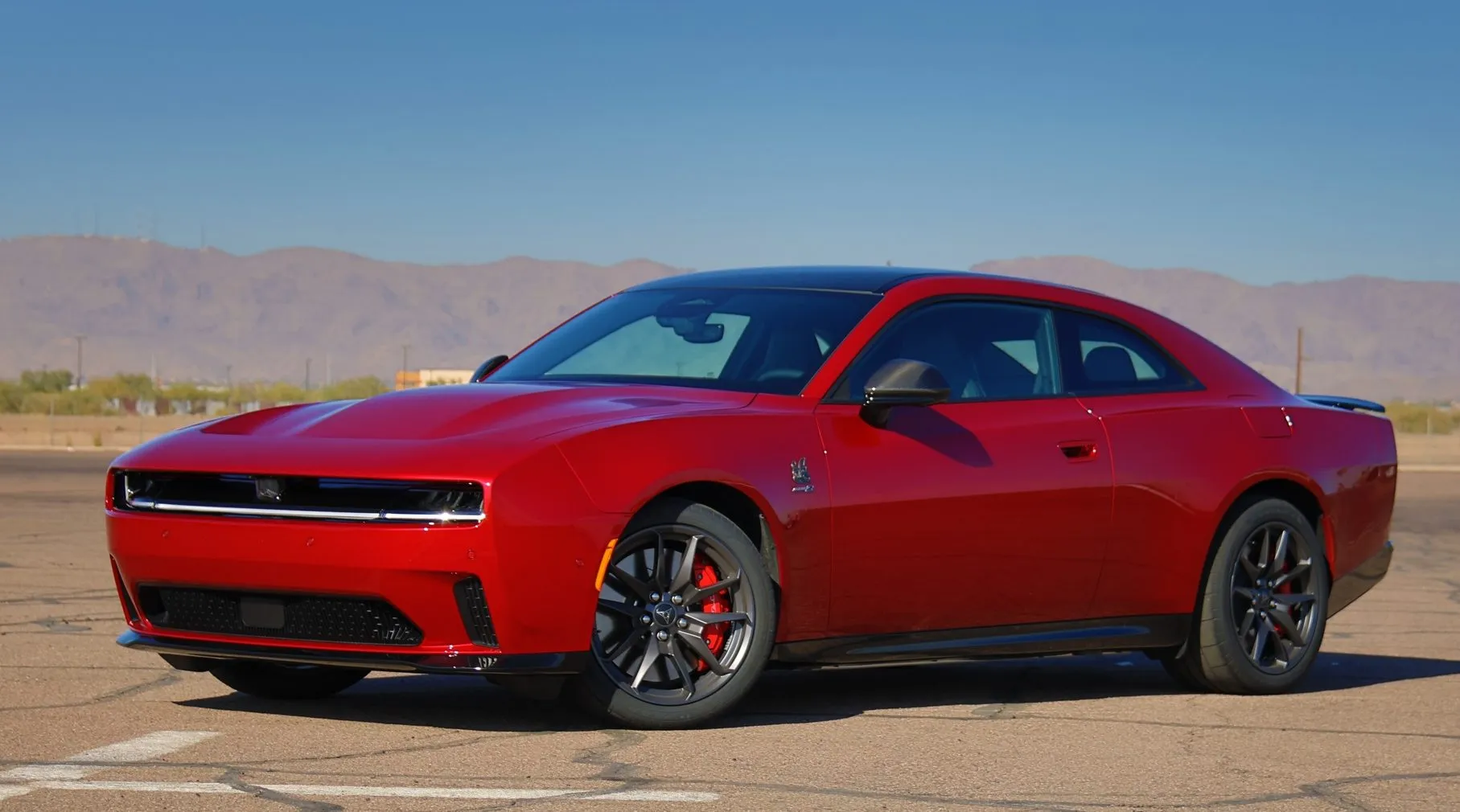 A close-up view of the rear Fratzonic Chambered Exhaust outlet on the 2024 Dodge Charger Daytona, featuring its distinctive comb-like slats and label.