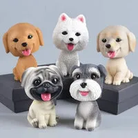 A collection of dog bobbleheads representing various breeds, lined up on a shelf.
