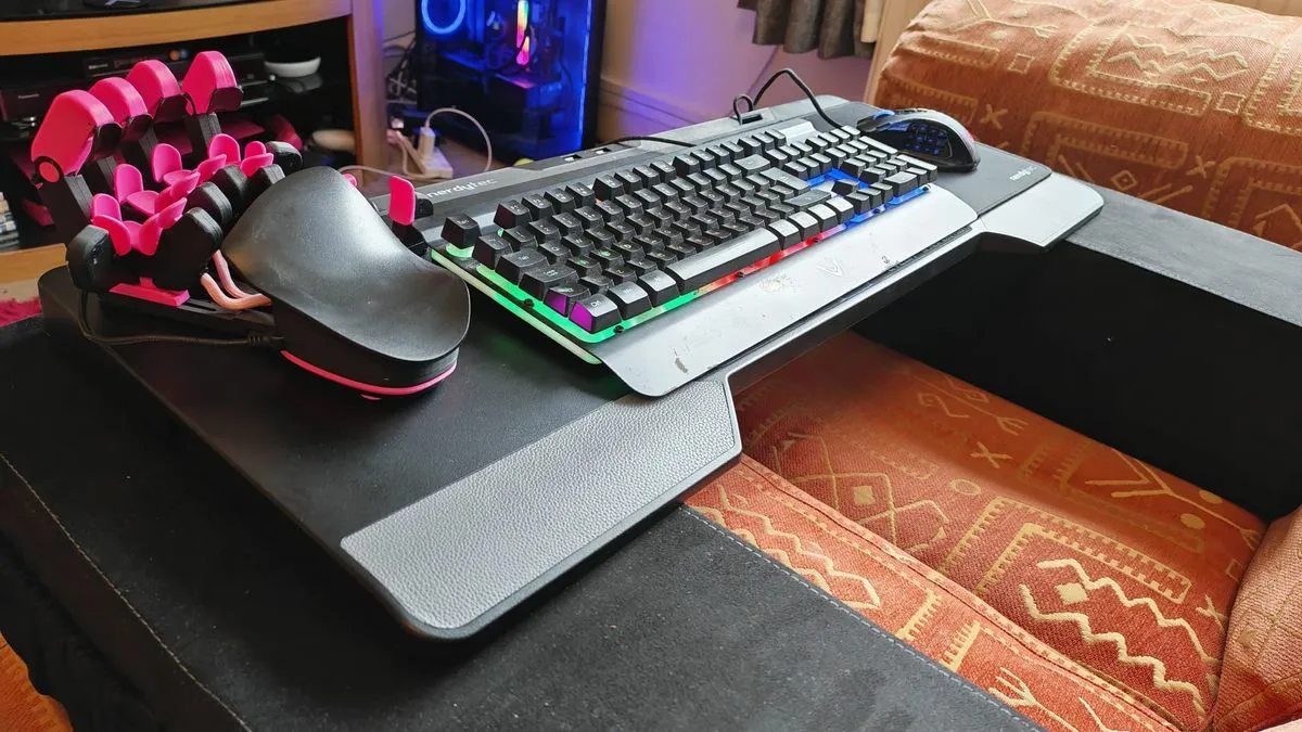 A Couchmaster Cycon 2 gaming desk setup with a mouse, keyboard, and gaming keypad on it, ready for immersive play