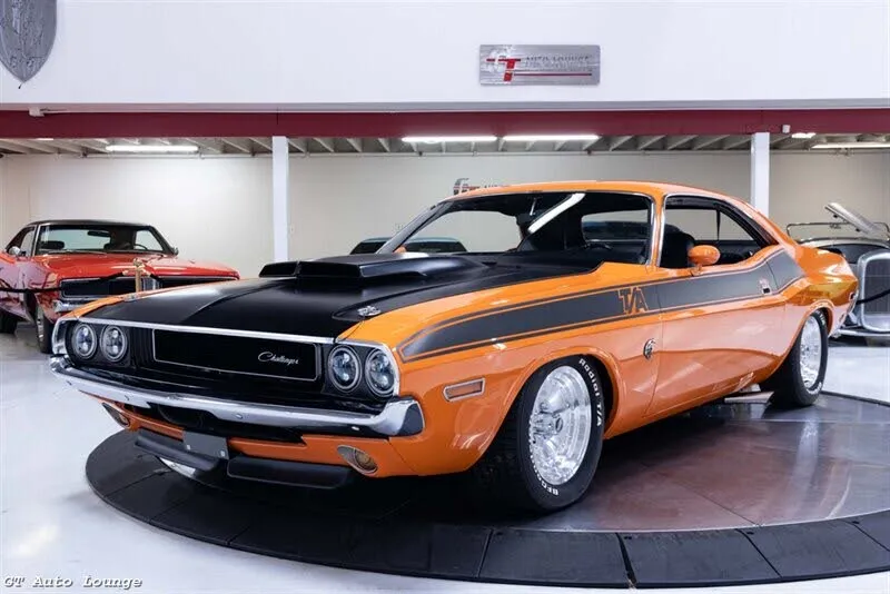 A dark green metallic 1970 Dodge Challenger restomod with a black interior.