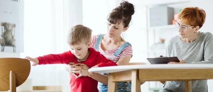 A dedicated practitioner carefully records observations and notes while watching a child's interactions.