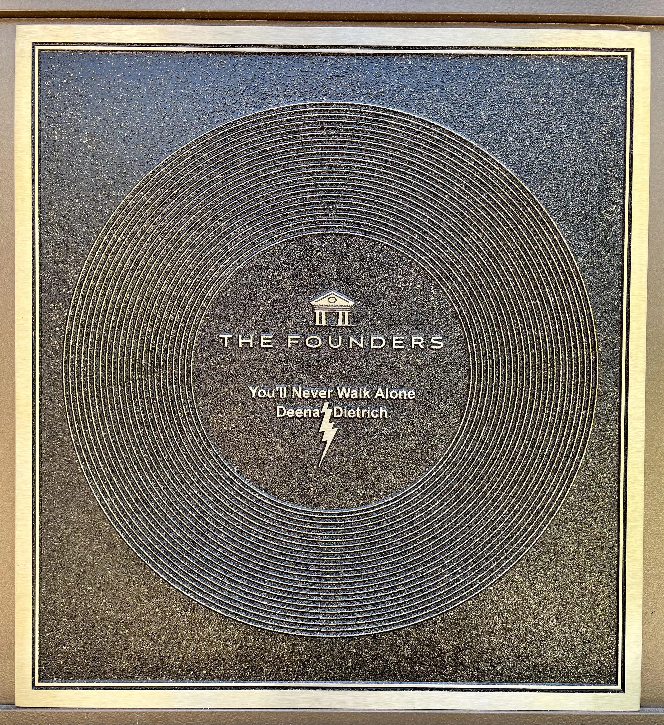 A Founders Plaque at Graceland with the inscription "You'll Never Walk Alone" and a name below it