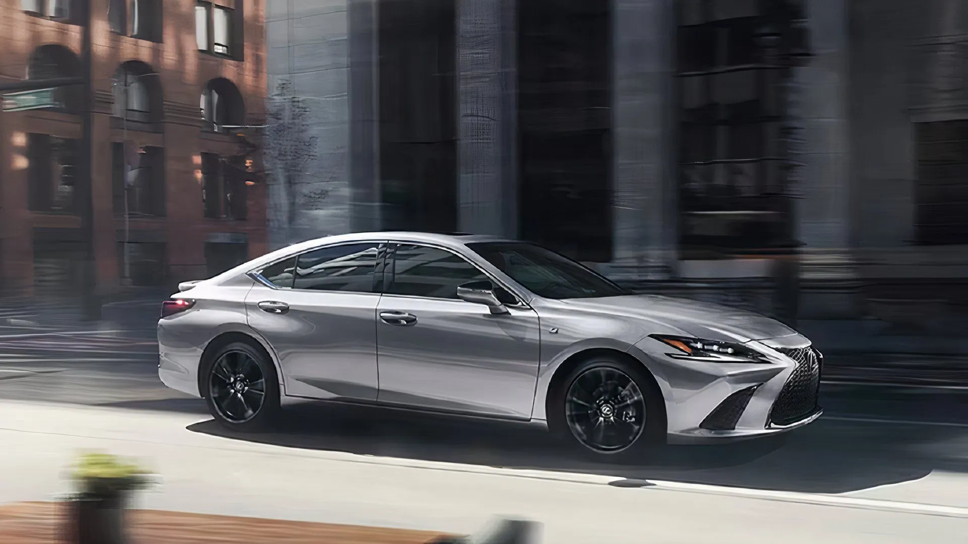 A gray 2025 Lexus ES 300h is driving.