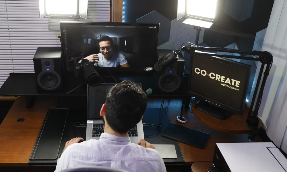 A man using Canon EOS Webcam Utility Pro software on a laptop with multiple camera feeds displayed