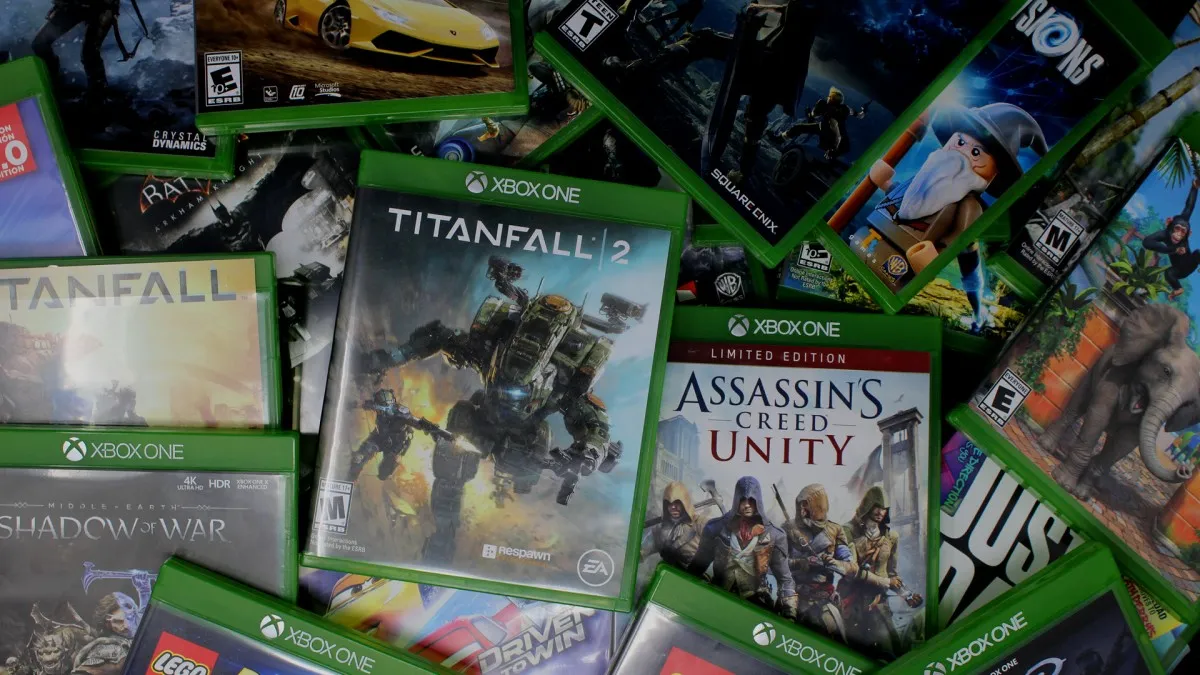 A person holding a physical game disc, with a digital game download icon floating beside it, symbolizing the debate between digital ownership and physical copies