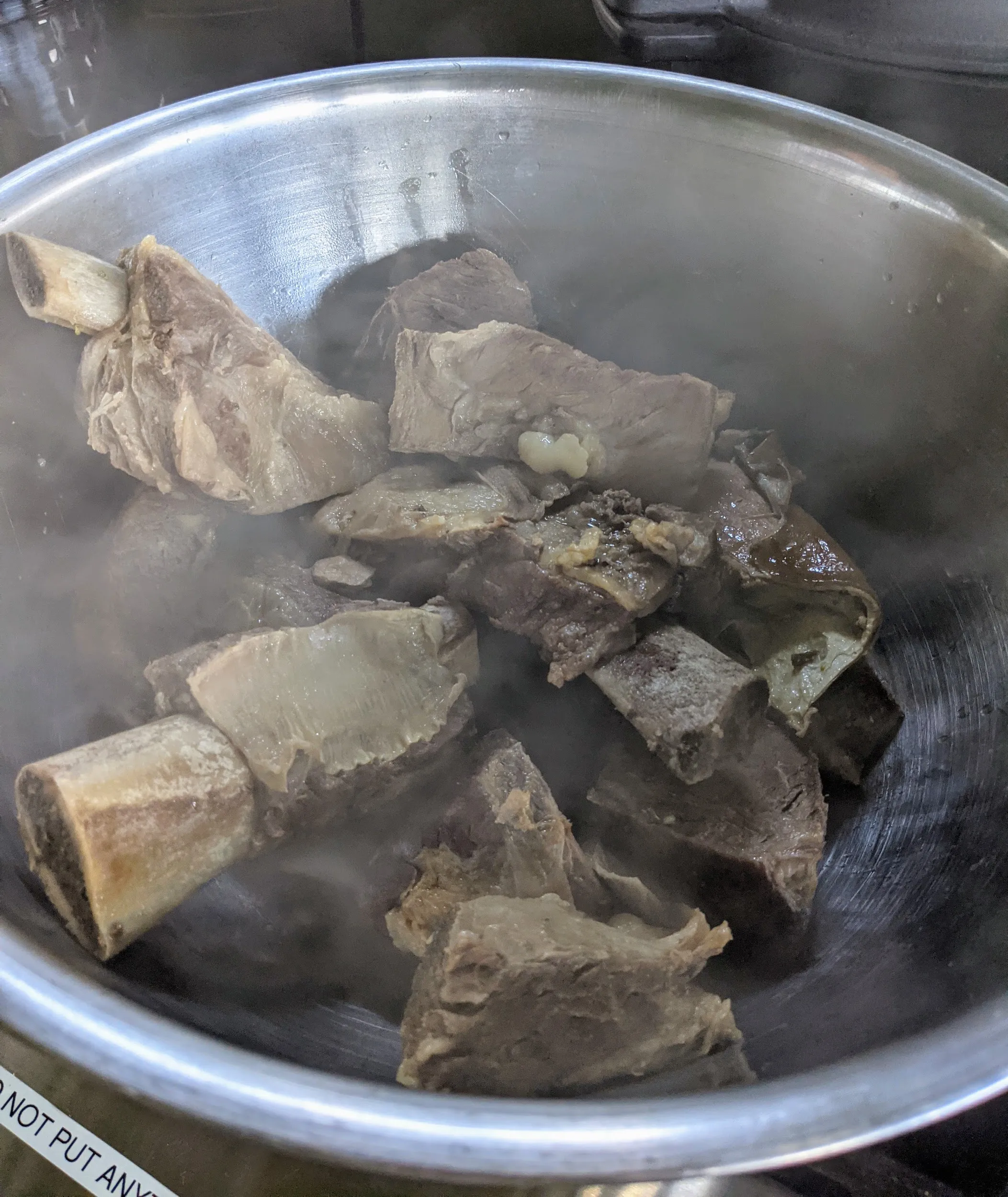 A pot of beef simmering on the stove, part of the multi-protein preparation for homemade dog food.