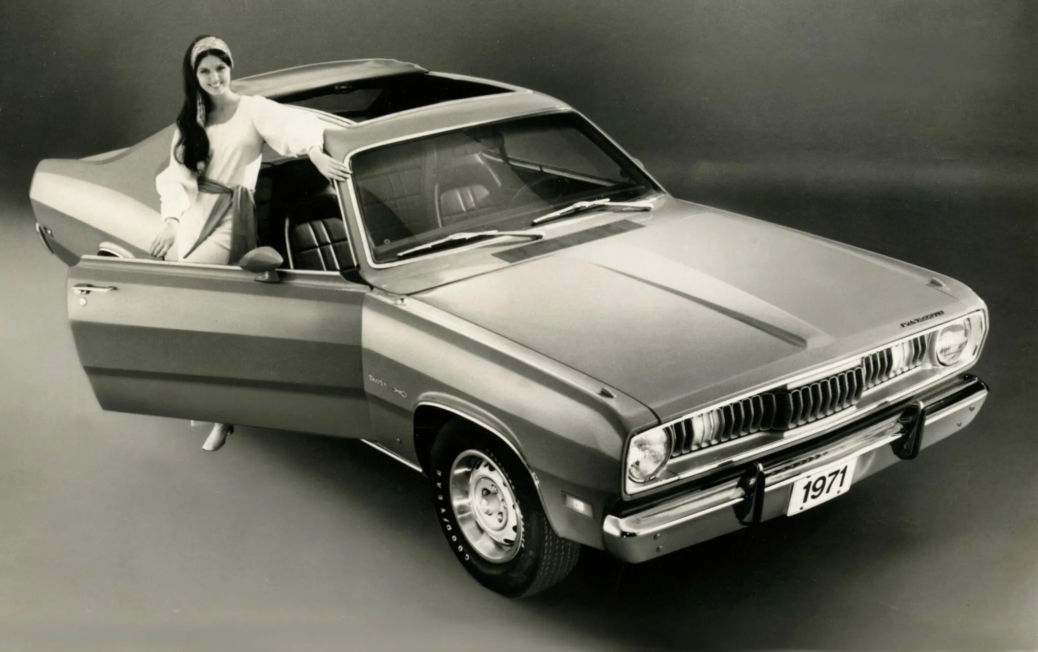 A rear three-quarter view of a 1971 Plymouth Duster, featuring the distinct "Sharktooth" grille and fastback design