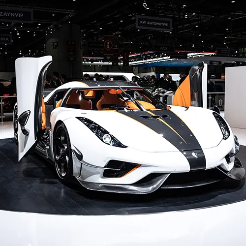 A silver Koenigsegg Regera parked on a paved surface, highlighting its unique design