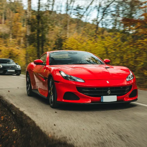 A sleek red Ferrari Portofino M parked on a scenic road, showcasing its elegant design