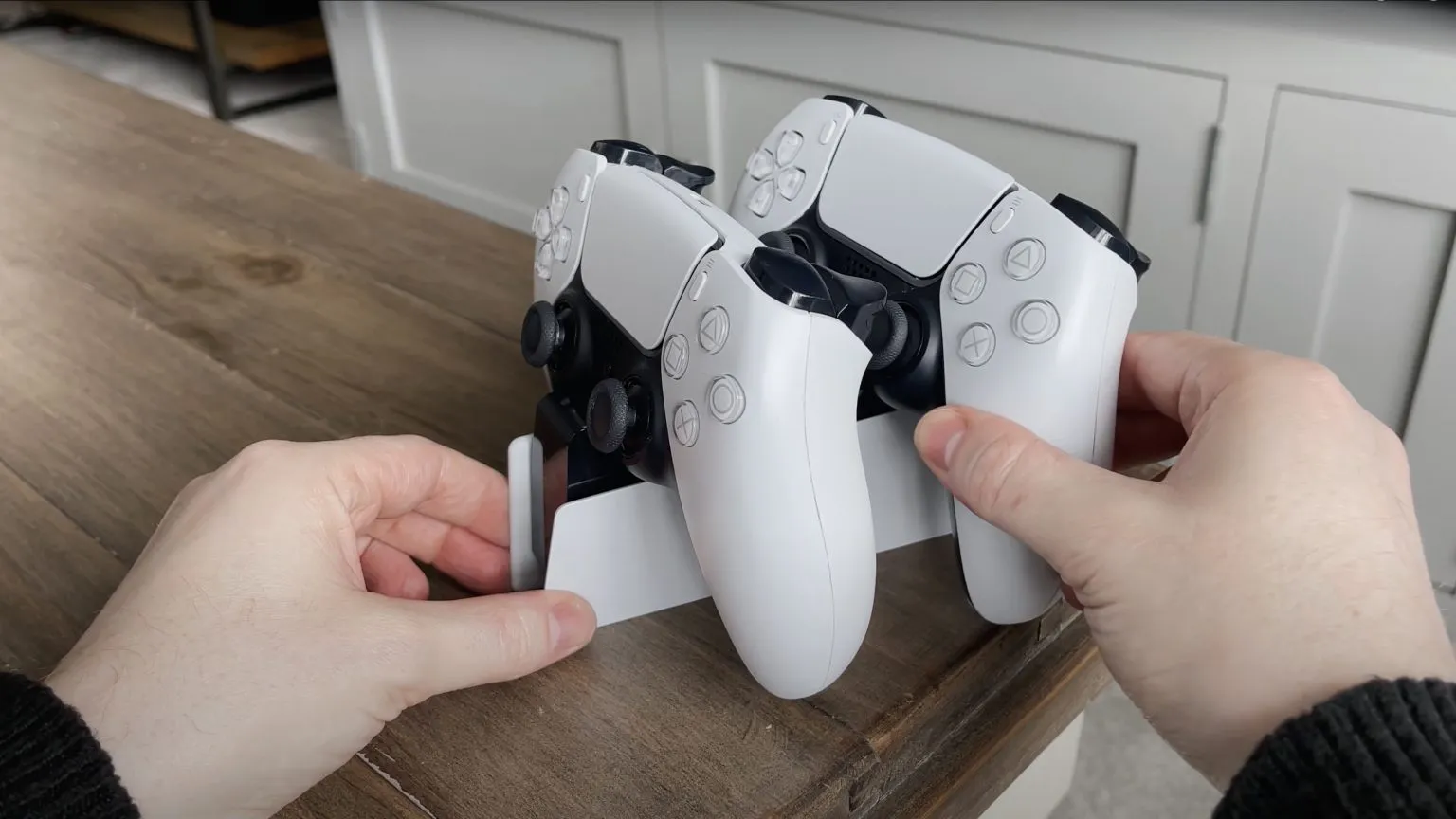 A Sony DualSense controller charging in a sleek black charging dock
