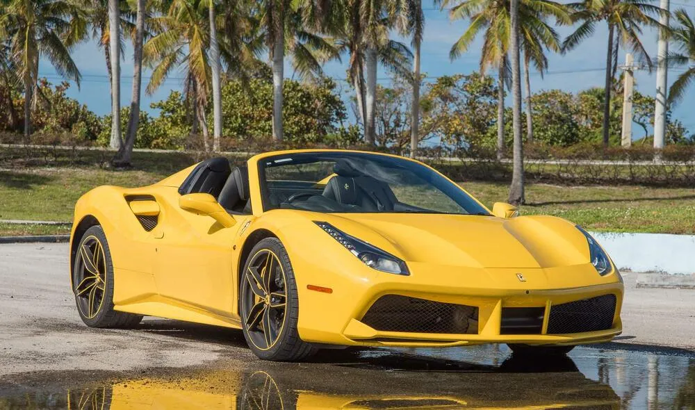 A stunning red Ferrari 488 Spider speeding down a coastal highway