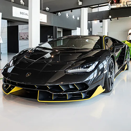 A vibrant yellow Lamborghini parked against a modern architectural background
