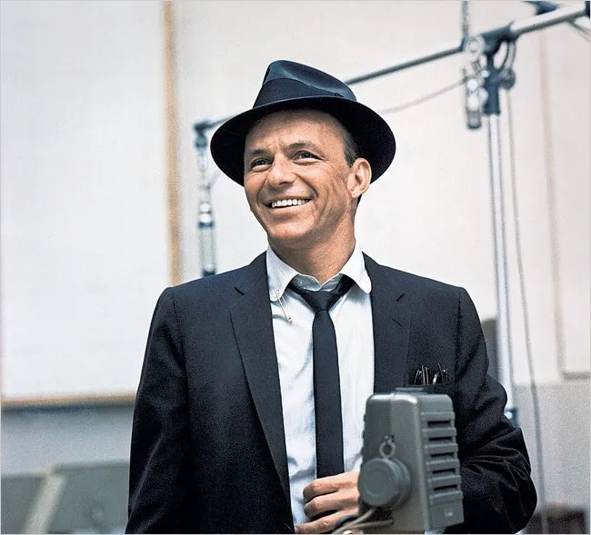 A young Frank Sinatra, around 24, performing with a microphone, during his early career with Tommy Dorsey's band.
