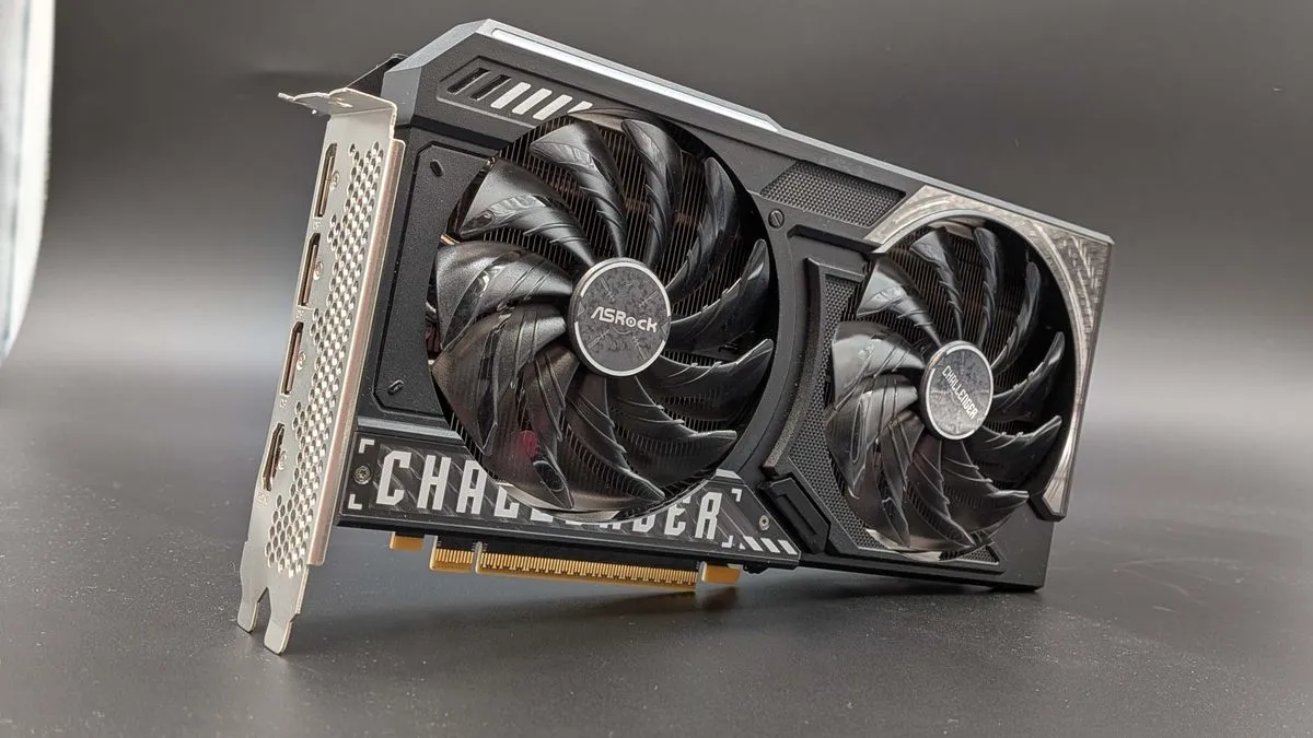 An Intel Arc B570 graphics card by ASRock, featuring a dual-fan cooler and a black and grey design, positioned against a light background.