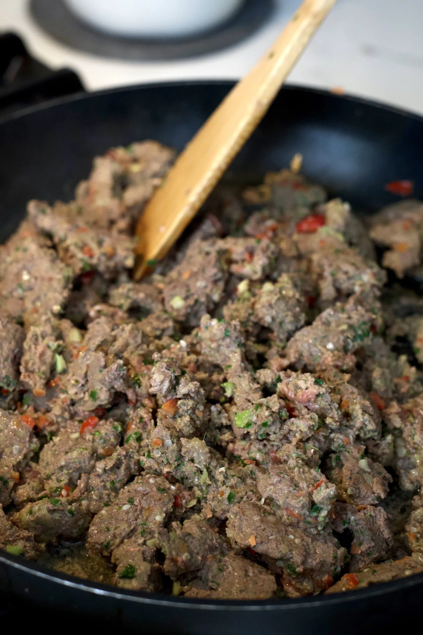 Assorted fresh ingredients for homemade dog food, including beef, eggs, and vegetables, laid out on a kitchen counter