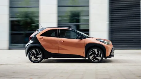 Best small hybrid cars: Toyota Aygo X Hybrid - side, orange, driving
