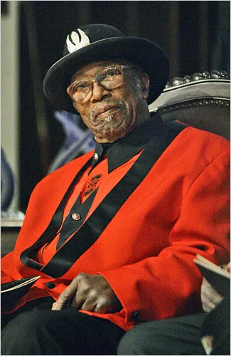 Bo Diddley performing with his signature rectangular guitar