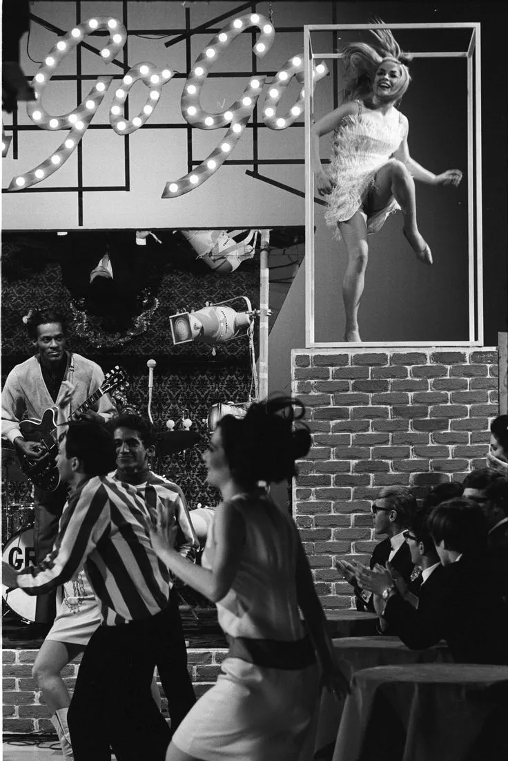 Chuck Berry performing on stage with a vibrant energy and his signature guitar