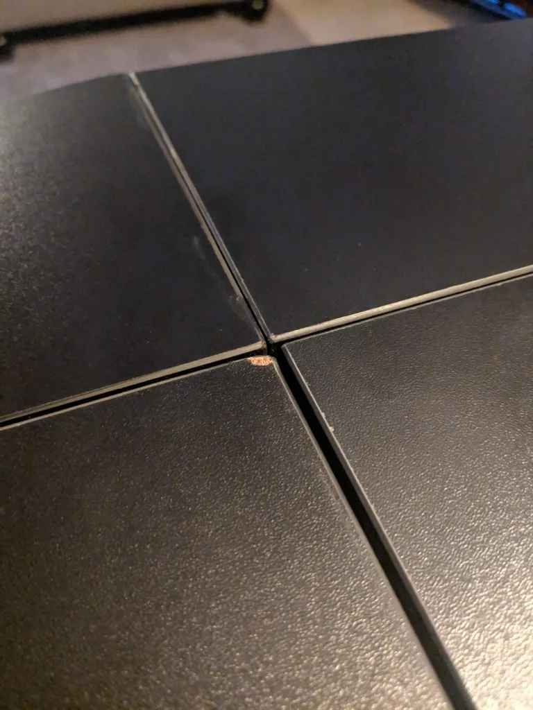 Close-up of the damaged topper, showing cracked veneer and glue residue