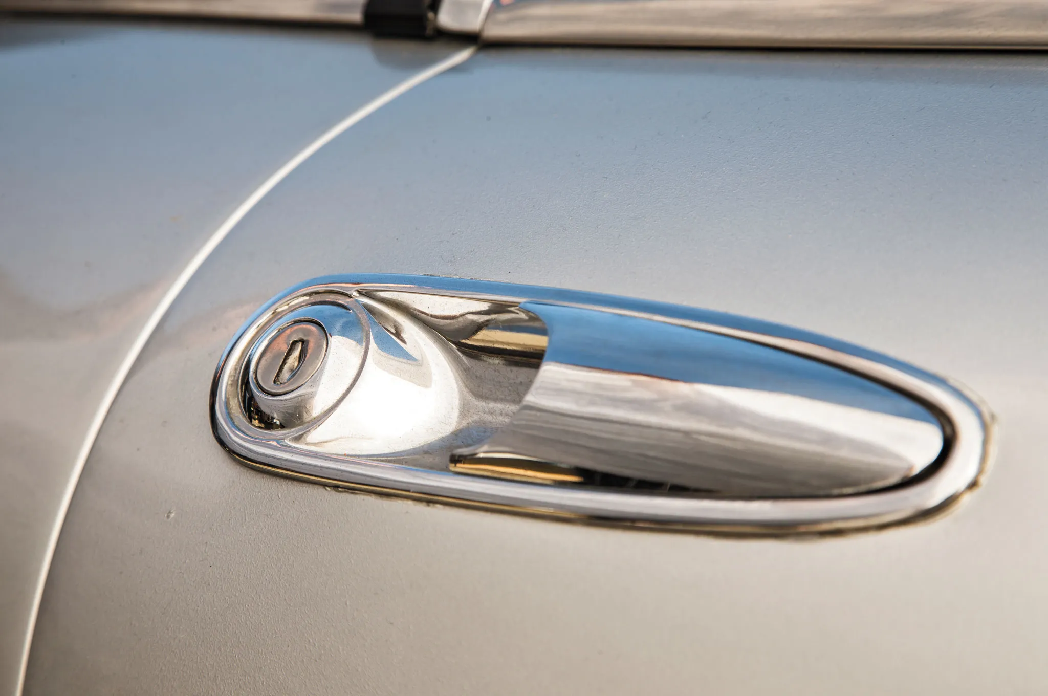 Close-up of the door handle and side mirror of a 1974 Alfa Romeo Spider Veloce 2000