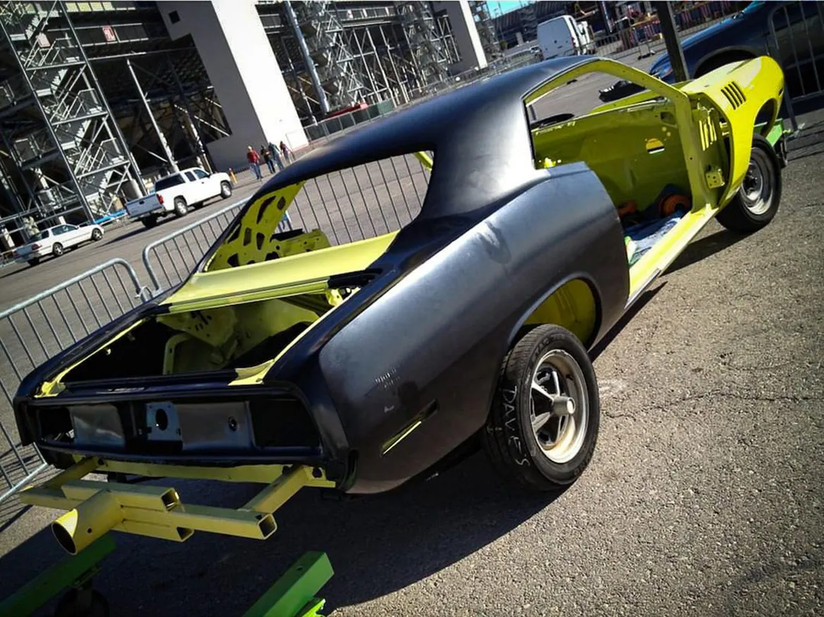Close-up of the partially assembled body of a 1971 Plymouth 'Cuda, showcasing the contours and readiness for paintwork.