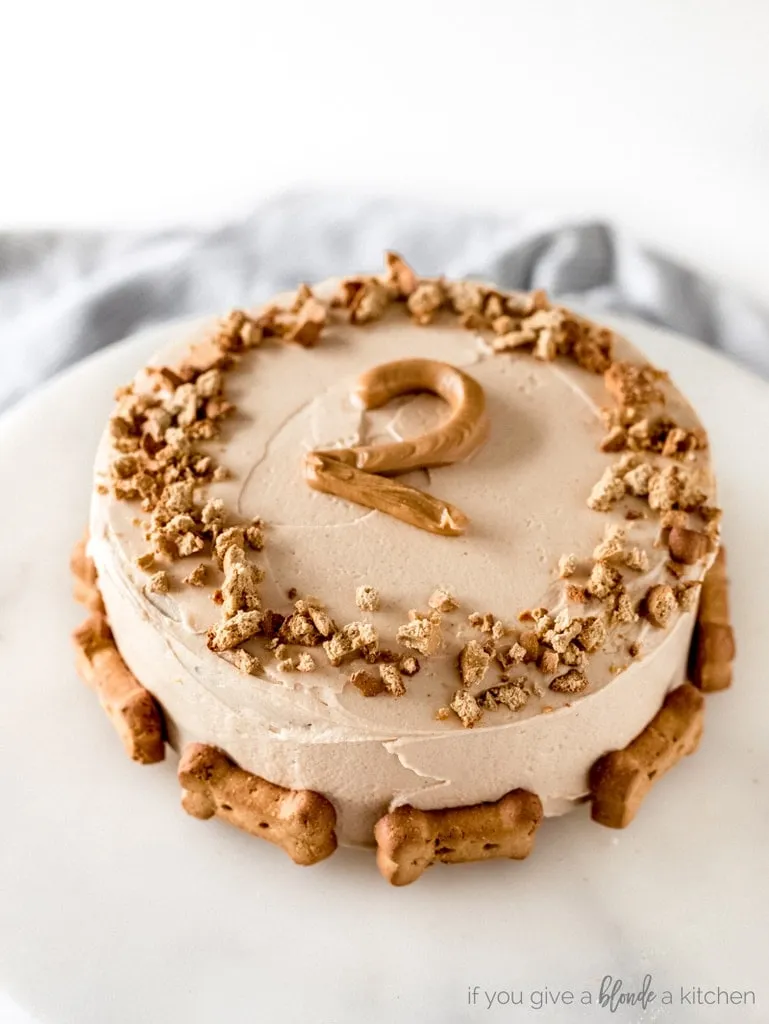 Delicious pumpkin dog cake with yogurt frosting and a peanut butter piped number '2' for a dog's birthday.