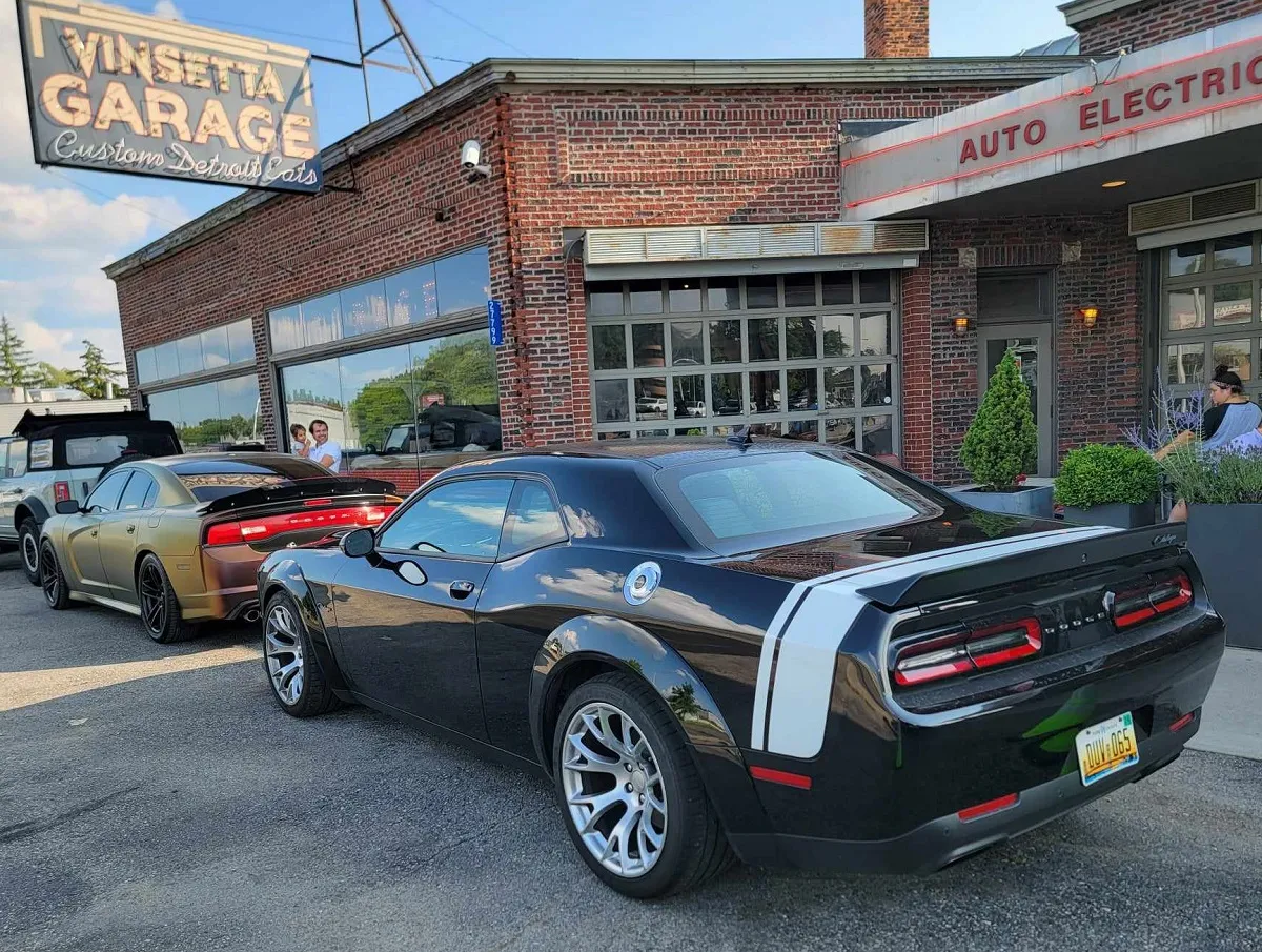 Dynamic front three-quarter view of the 2023 Dodge Challenger Black Ghost, emphasizing its sleek lines and aggressive stance on the open road.