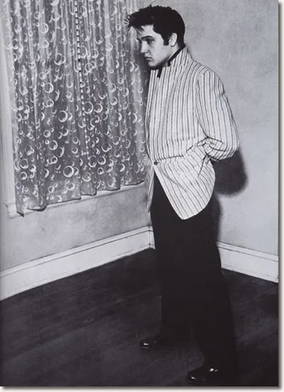 Elvis is proudly standing in Graceland, which he recently bought.