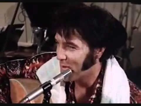 Elvis Presley laughing on stage during a performance