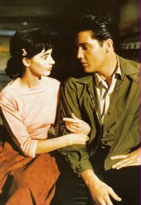 Elvis Presley singing in "Wild in the Country" alongside Millie Perkins, capturing a moment of on-screen musicality.