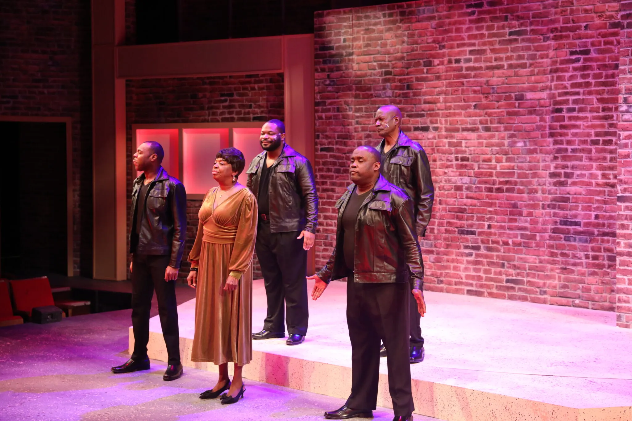 Ensemble cast performing dynamic group scene from the production
