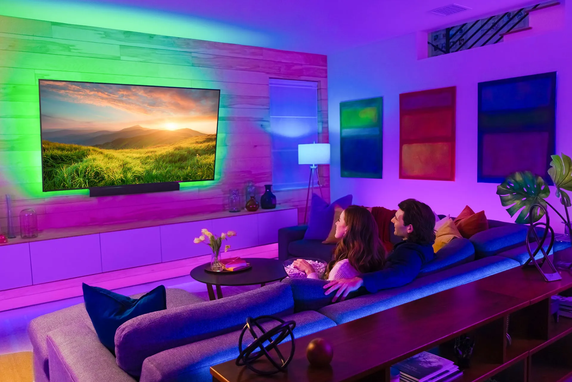 Flexible LED strip lights illuminating a modern gaming desk in a vibrant living room