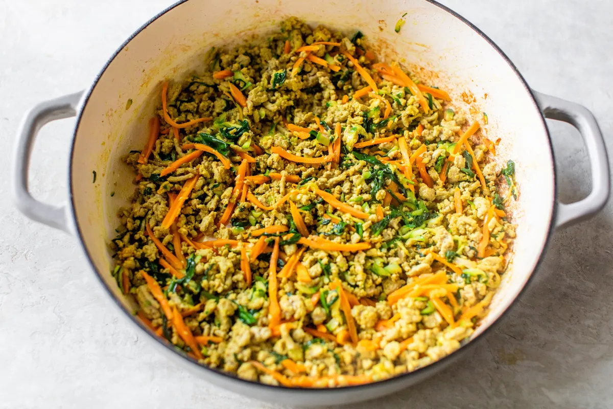 Fresh veggies added to browned ground turkey in a large pot