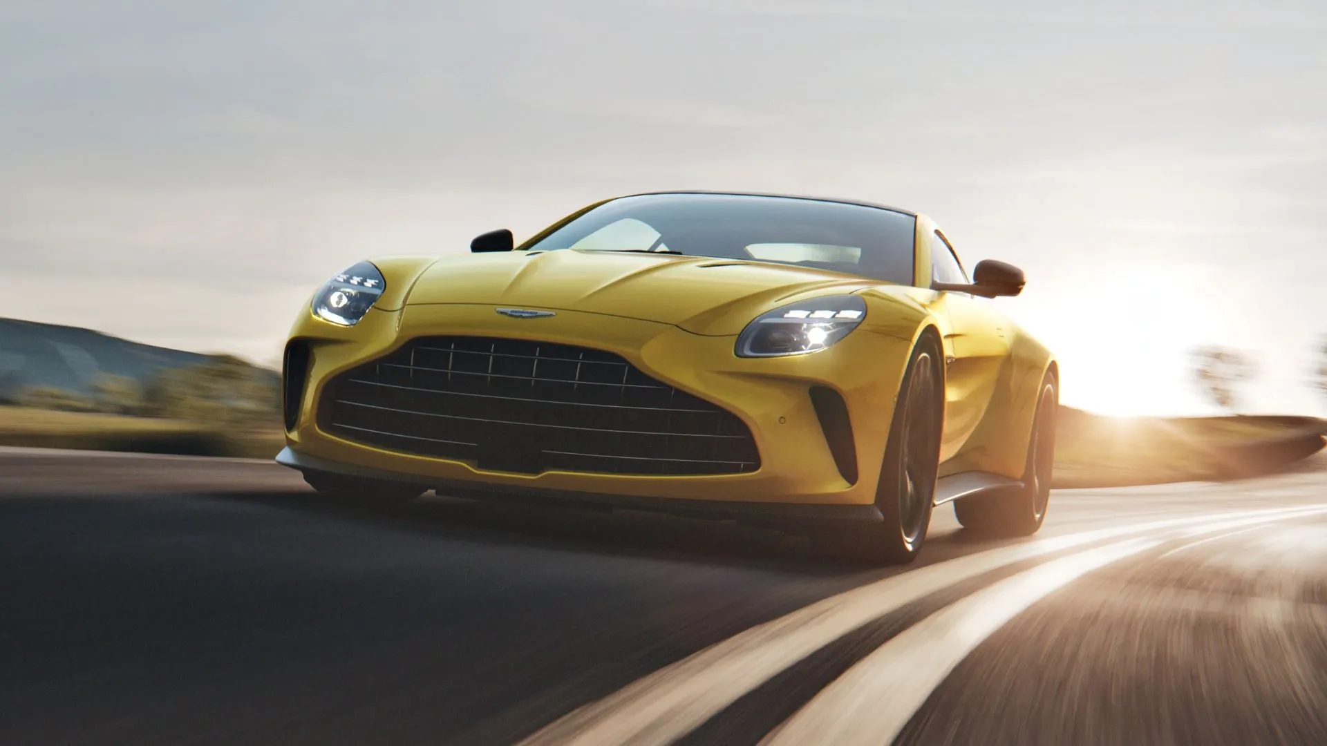 Front three-quarter action shot of a yellow 2025 Aston Martin Vantage